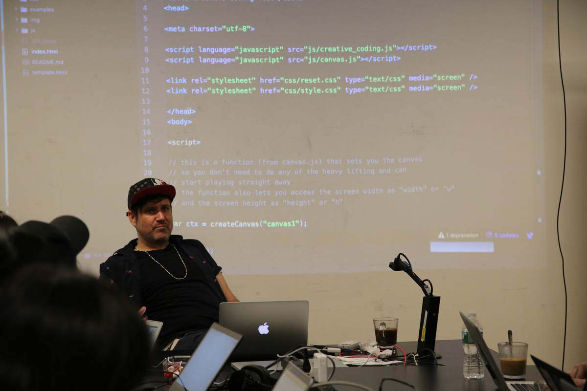a man giving a lecture with code in the background